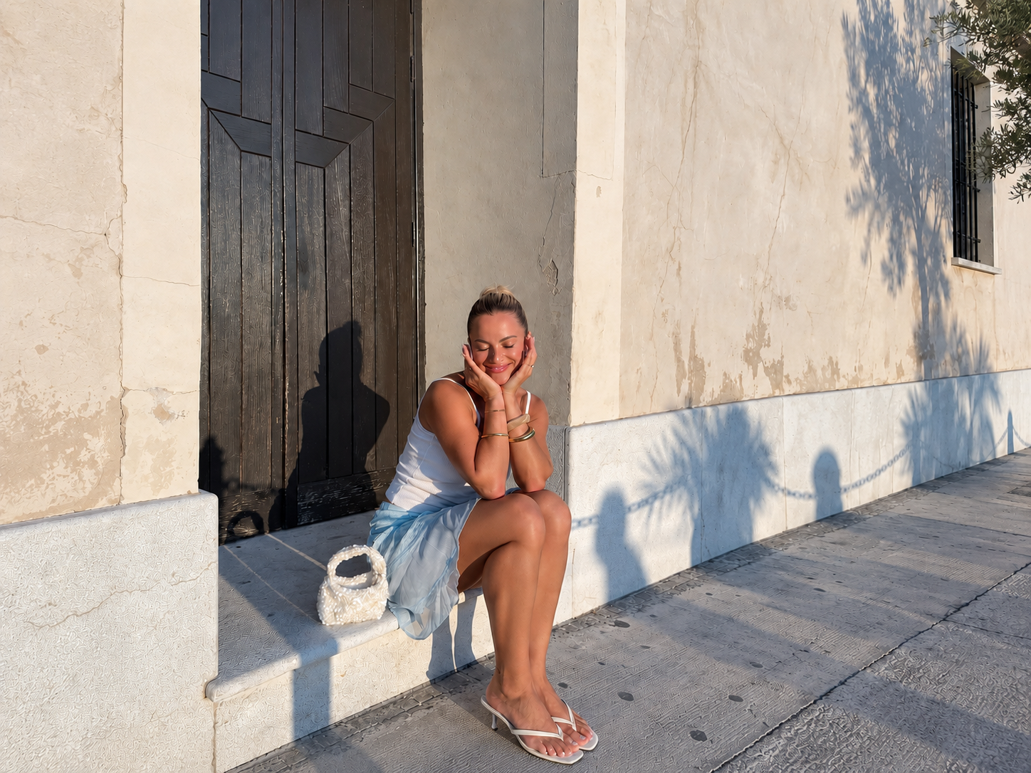 Woman sitting in a sunlit doorway reviewing her cycle patterns with Fibra